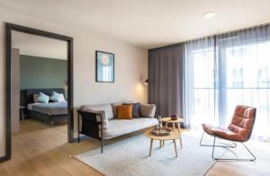 a living room with a couch and a mirror at ipartment Boeblingen @HOME by Best Western in Böblingen