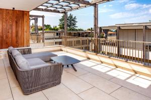 a patio with a couch and a table on a deck at The Penthouse Bardolino in Bardolino