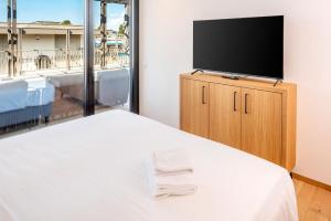 a bedroom with a bed and a flat screen tv at The Penthouse Bardolino in Bardolino