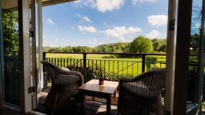 a porch with two chairs and a table with a view at Restaurant Hotel Merlet in Schoorl