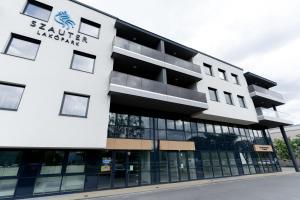 a building with a sign on the front of it at Szauter Aparthomes A in Győr