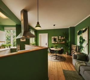 a kitchen and living room with green walls at Greenbrook Homes - Family 7PPL in Aalborg