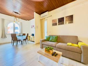 a living room with a couch and a table at Demetra Seafront Apartment - Parking & Pool in Castel Volturno