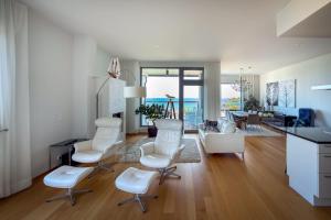 a living room with white chairs and a kitchen at Panorama Suite in Hanko in Hanko