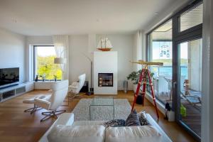 a living room with a white couch and a fireplace at Panorama Suite in Hanko in Hanko