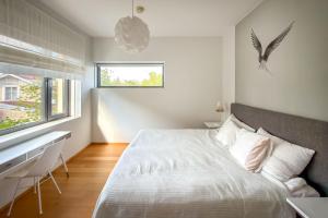 a bedroom with a bed and a desk and a window at Panorama Suite in Hanko in Hanko +15 photos