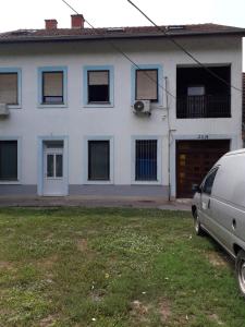 a white house with a van parked in front of it at Petrovic in Sombor