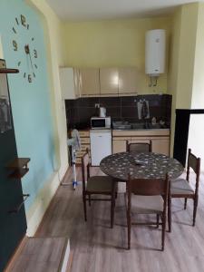 a small kitchen with a table and chairs in a room at Petrovic in Sombor