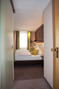 Schlafzimmer mit einem Bett und einem Fenster in der Unterkunft Hotel-Restaurant Arneggers Adler in Tiefenbronn