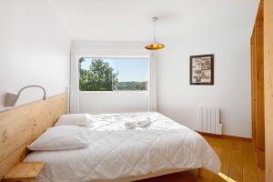 a white bedroom with a large bed with a window at Gite Design La Station in Angoisse +29 photos