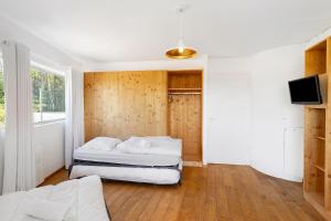 a bedroom with two beds and a flat screen tv at Gite Design La Station in Angoisse