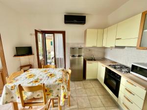 a kitchen with a table and a kitchen with a stove at Rosmarino Apartment in Seccheto +8 photos