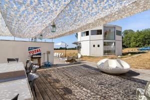 a patio with a table and chairs and a building at Gite Design La Station in Angoisse