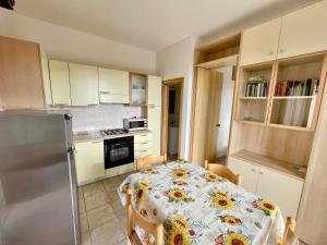 a small kitchen with a table and a refrigerator at Rosmarino Apartment in Seccheto