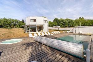 a house with a swimming pool on a wooden deck at Gite Design La Station in Angoisse