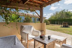 a patio with a table and chairs and a pergola at Chambres D'hotes Le Cocon De Lily in Saint-Avit