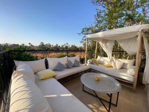 a patio with a white couch and a canopy at Villa Bouchra in Marrakesh