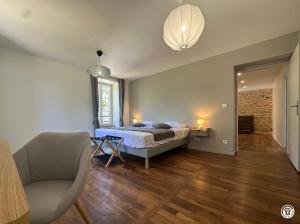 a bedroom with a bed and a chair and a window at La Ferme de Sainte Isabelle in Montlay-en-Auxois