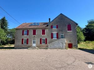 a large stone house with red shuttered windows at La Ferme de Sainte Isabelle in Montlay-en-Auxois