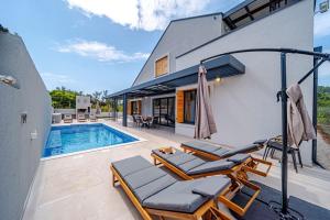 a patio with chairs and a swimming pool at Villa Plitvina in Vela Luka