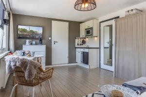 a kitchen and living room with a table and chairs at 50112 Ferienwohnung "Coco" in Carolinensiel