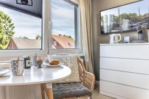 a kitchen with a table and two windows at 50112 Ferienwohnung "Coco" in Carolinensiel