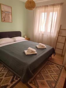 a bedroom with a bed with two towels on it at Ema & Jakov in Sreser