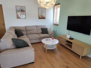 a living room with a couch and a flat screen tv at Ema & Jakov in Sreser