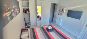 a living room with a bed and a tv at Chez Manon et Stéphane in Prissé