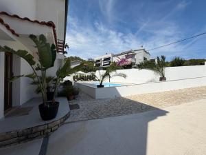 a balcony of a house with a pool and plants at Apartment Ana Pool Residence in Preko