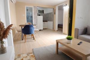 a living room with a table and a blue chair at Petit villa centre harhoura Près de la plage in Temara
