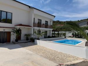 a villa with a swimming pool and a house at Apartment Ana Pool Residence in Preko