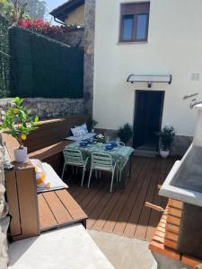 a patio with a table and chairs on a deck at Atardecer en Gulpiyuri By Silastur in Naves +37 photos
