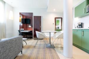 a kitchen and living room with a table and chairs at Privilège Appart Hôtel Saint Exupéry in Toulouse