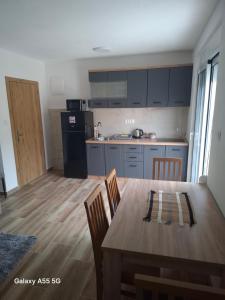 a kitchen with a wooden table and a dining room at Nido Apartman in Kotor