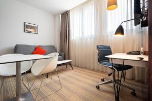 a meeting room with two tables and chairs at Privilège Appart Hôtel Saint Exupéry in Toulouse +38 photos