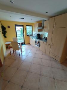 a kitchen with a tiled floor and a table at Hainich-Ferienwohnung in Hörselberg-Hainich