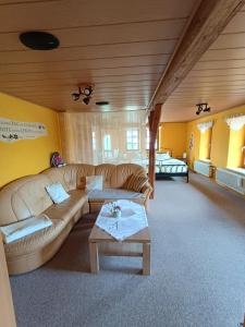 a living room with a couch and a table at Hainich-Ferienwohnung in Hörselberg-Hainich