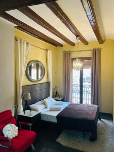 a bedroom with a large bed and a red chair at Font 1 Circo Romano in Tarragona