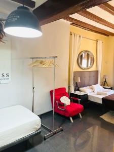 a room with two beds and a red chair at Font 1 Circo Romano in Tarragona