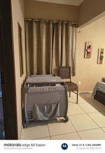 a bed sitting in a room next to a window at Casa Hostel Essenza di Donna in São Luís