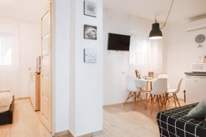a small apartment with white walls and a dining room at Forest Apartman in Makó
