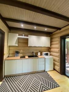 a kitchen with white cabinets and a microwave at Подих Лісу 2 in Synevyrsʼka Polyana