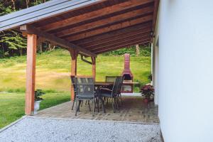 a patio with a table and chairs under a roof at Kuća za odmor Čevo in Podevčevo