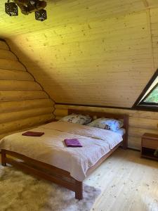 a bedroom with a bed in a log cabin at Подих Лісу 2 in Synevyrsʼka Polyana