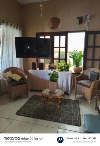 a living room with a table and a tv at Casa Hostel Essenza di Donna in São Luís