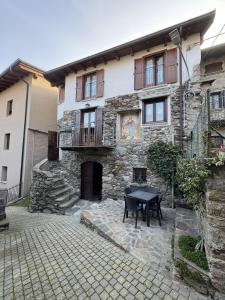 a stone house with a table in front of it at Casa Patty in Civo +9 photos
