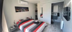 a bedroom with a bed and a bathroom with a sink at Chez Manon et Stéphane in Prissé