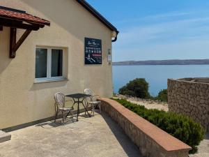a table and chairs outside of a building with a view of the water at Bei Marko in Barić Draga