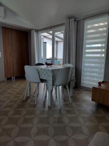 a dining room with a table and white chairs at Bienvenue chez Diamina et Patrick in La Tremblade +3 photos